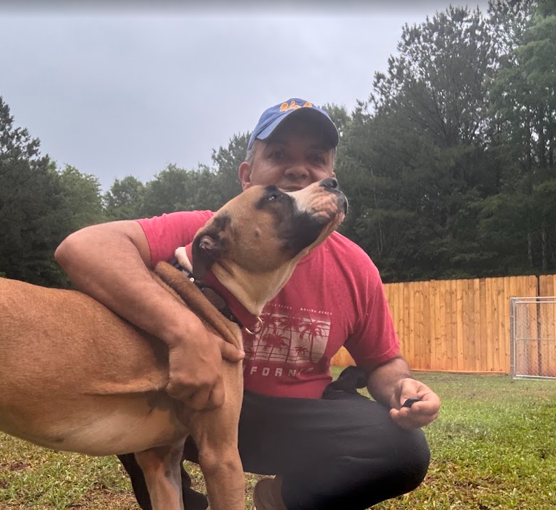 Kaio sharing an affectionate moment with a dog in the Dog Friends yard