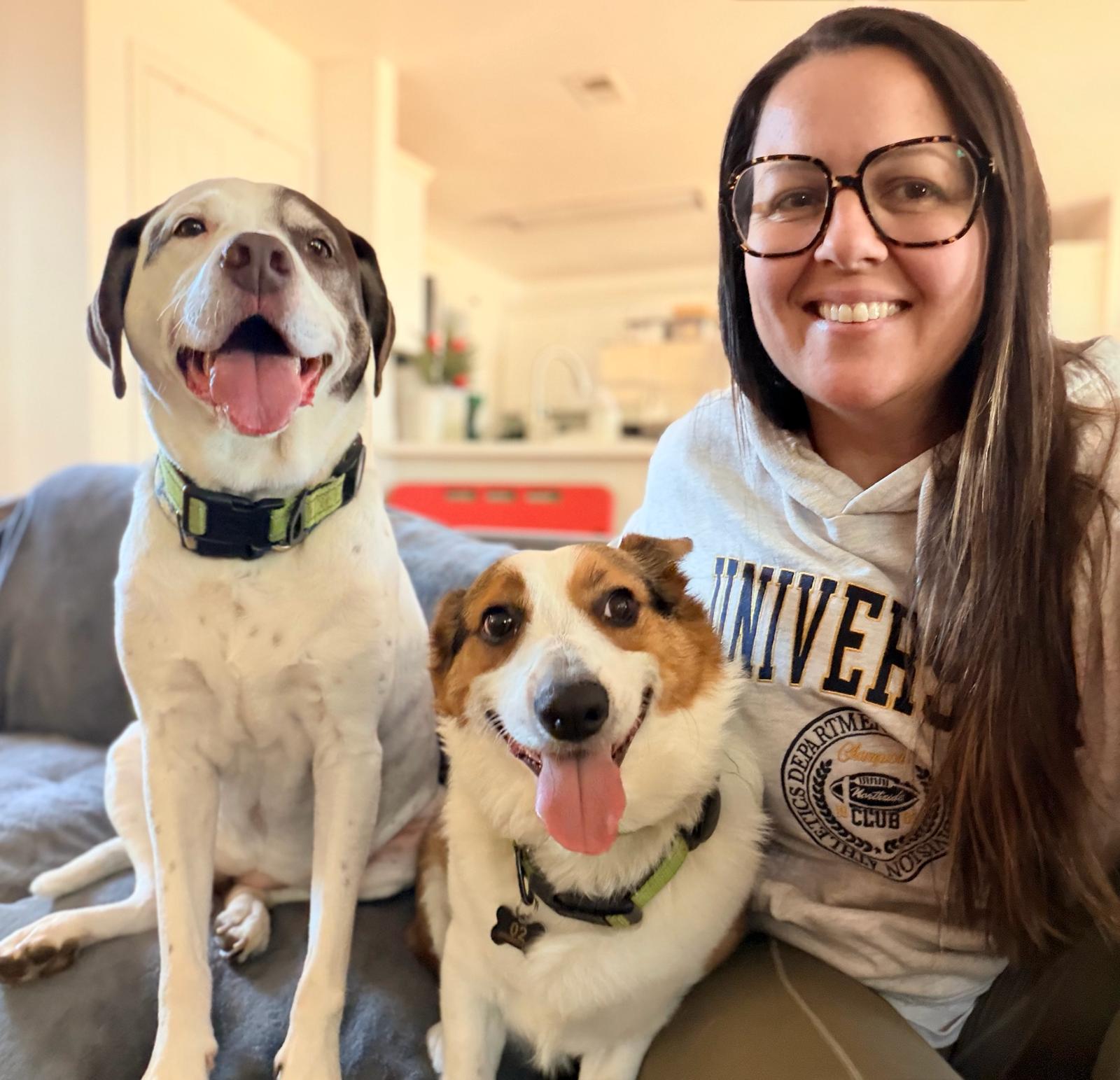 A Dog Friends caregiver sharing a happy moment at home with two dogs
